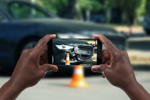 Man photographing his car with damages